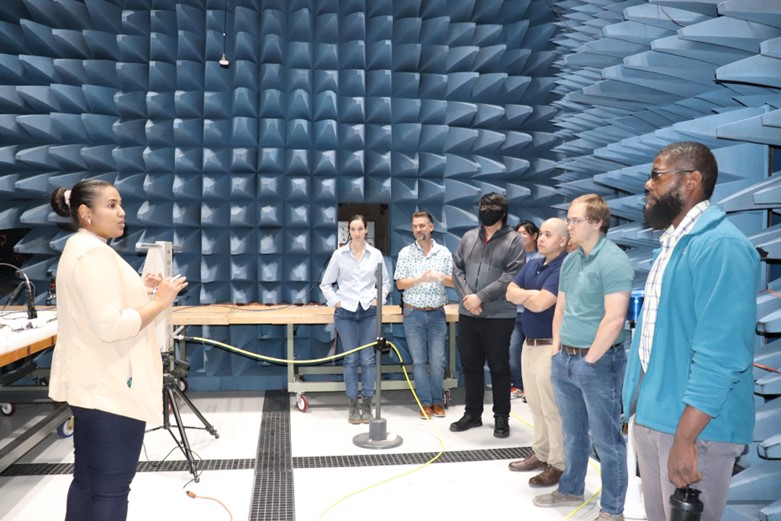 A group of people standing in a soundproof chamber with foam spikes.