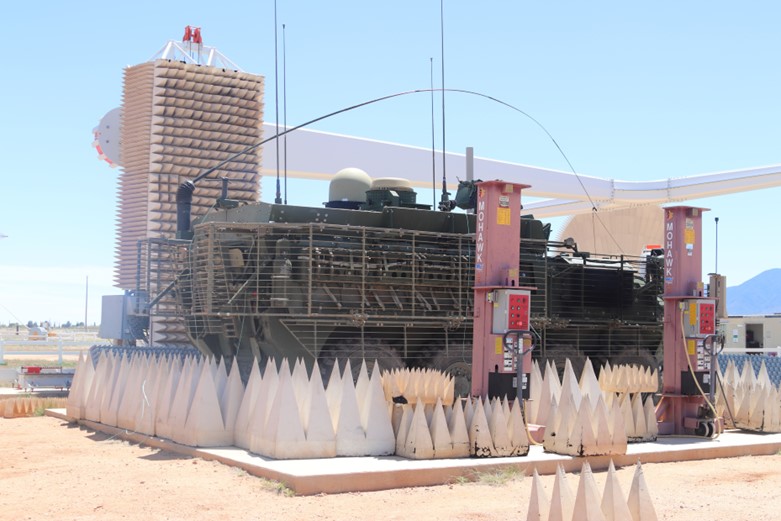 A military vehicle surrounded by foam spikes and a lift.