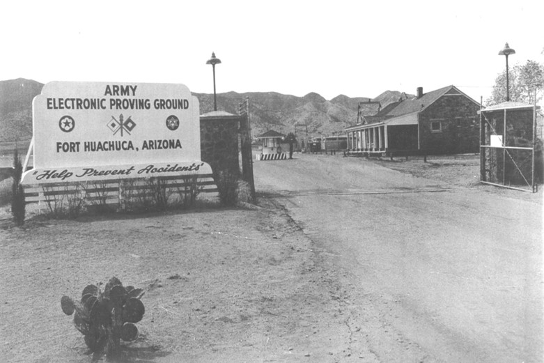 A black and white photo with a sign reading Army Electronic Proving Ground Fort Huachuca, Arizona. Bottom text reads Help Prevent Accidents.