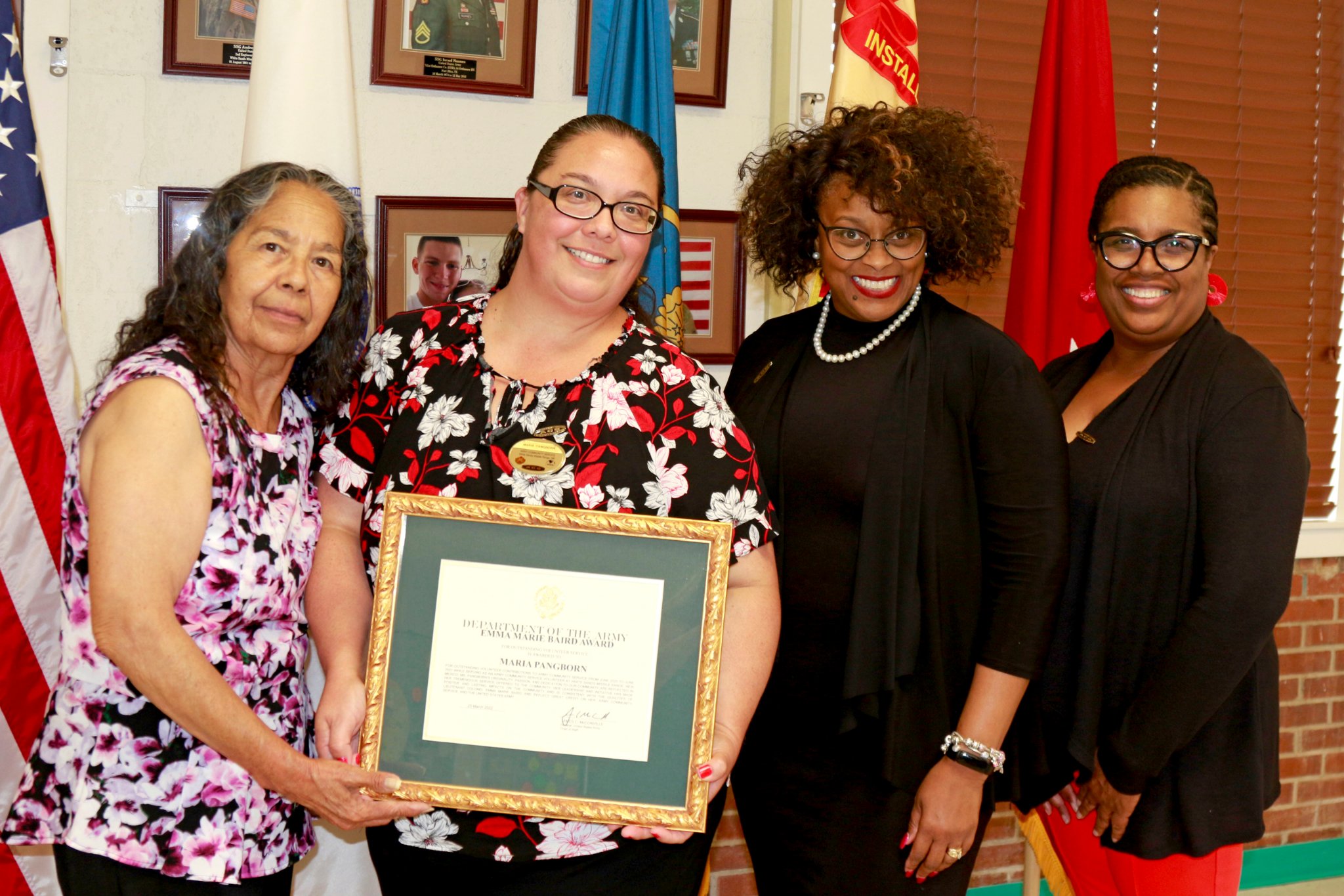 A group of women holding up a framed award