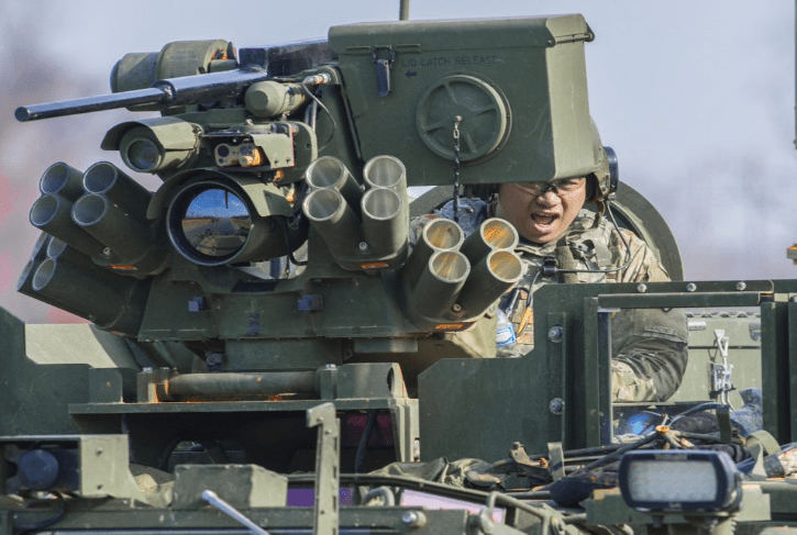 A soldier is sitting at a gun turret.